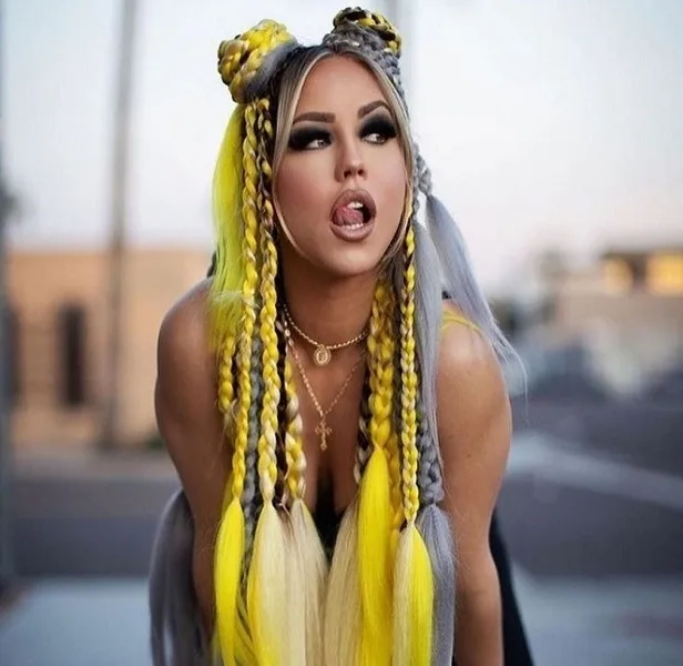 A woman with long yellow and gray braids styled into buns.